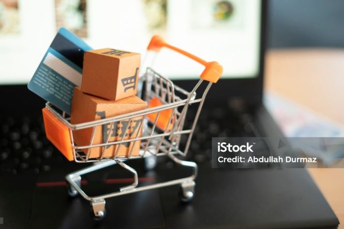 Is the payment cash or credit card? Shopping trolley and small boxes on laptop.