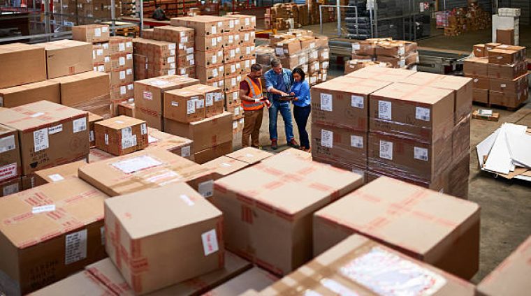 Shot of people at work in a large warehouse full of boxes