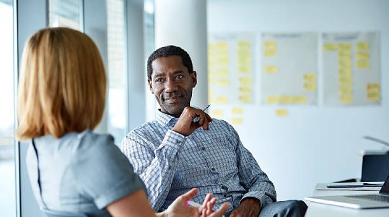 Shot of two colleagues talking together in a modern office