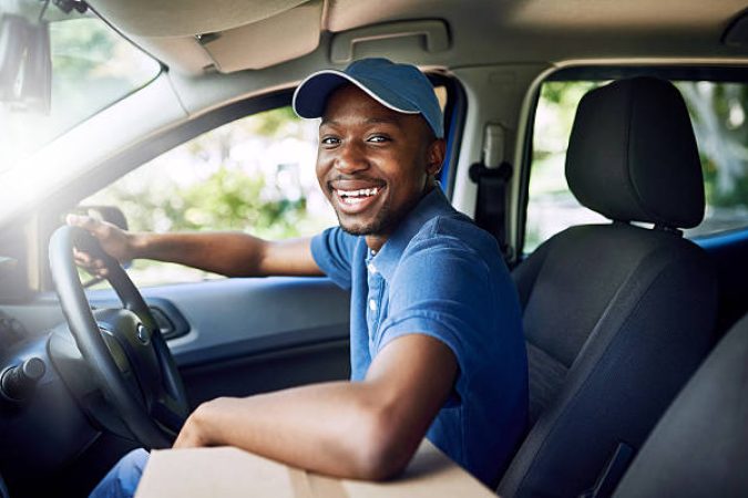 Portrait of a young postal working sitting in his car during a delivery