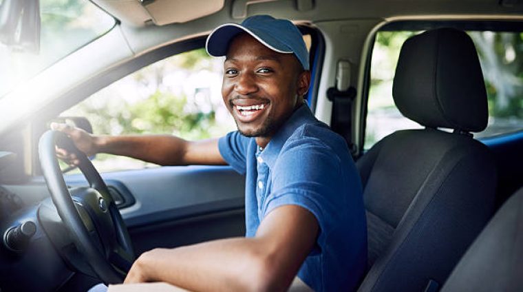Portrait of a young postal working sitting in his car during a delivery