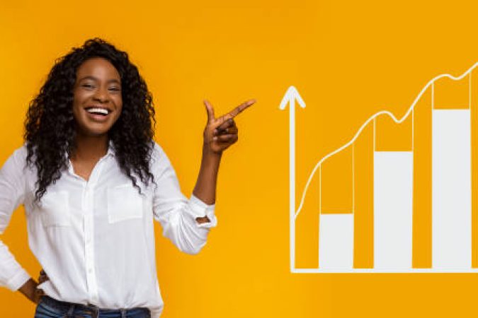 Smiling African American woman pointing aside at business graph