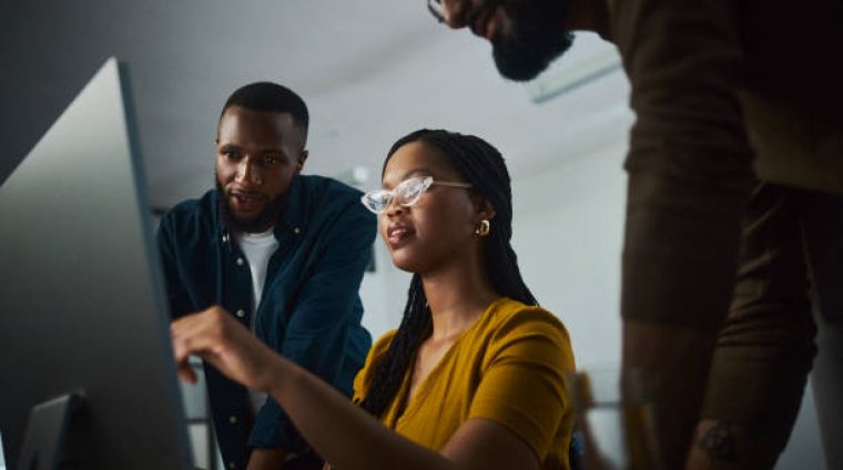 A motivated entrepreneurs working tirelessly at a desktop computer, showcasing their dedication to success. Their focused expressions and engaged body language convey their commitment to accomplishing their goals even during late hours.